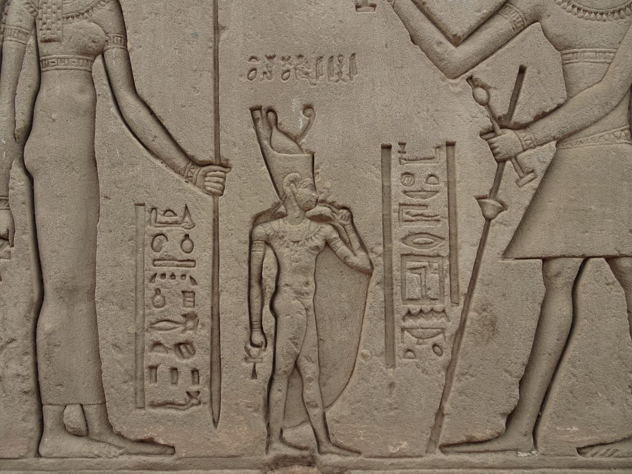 intricate stone relief of ancient egyptian figures and hieroglyphs
