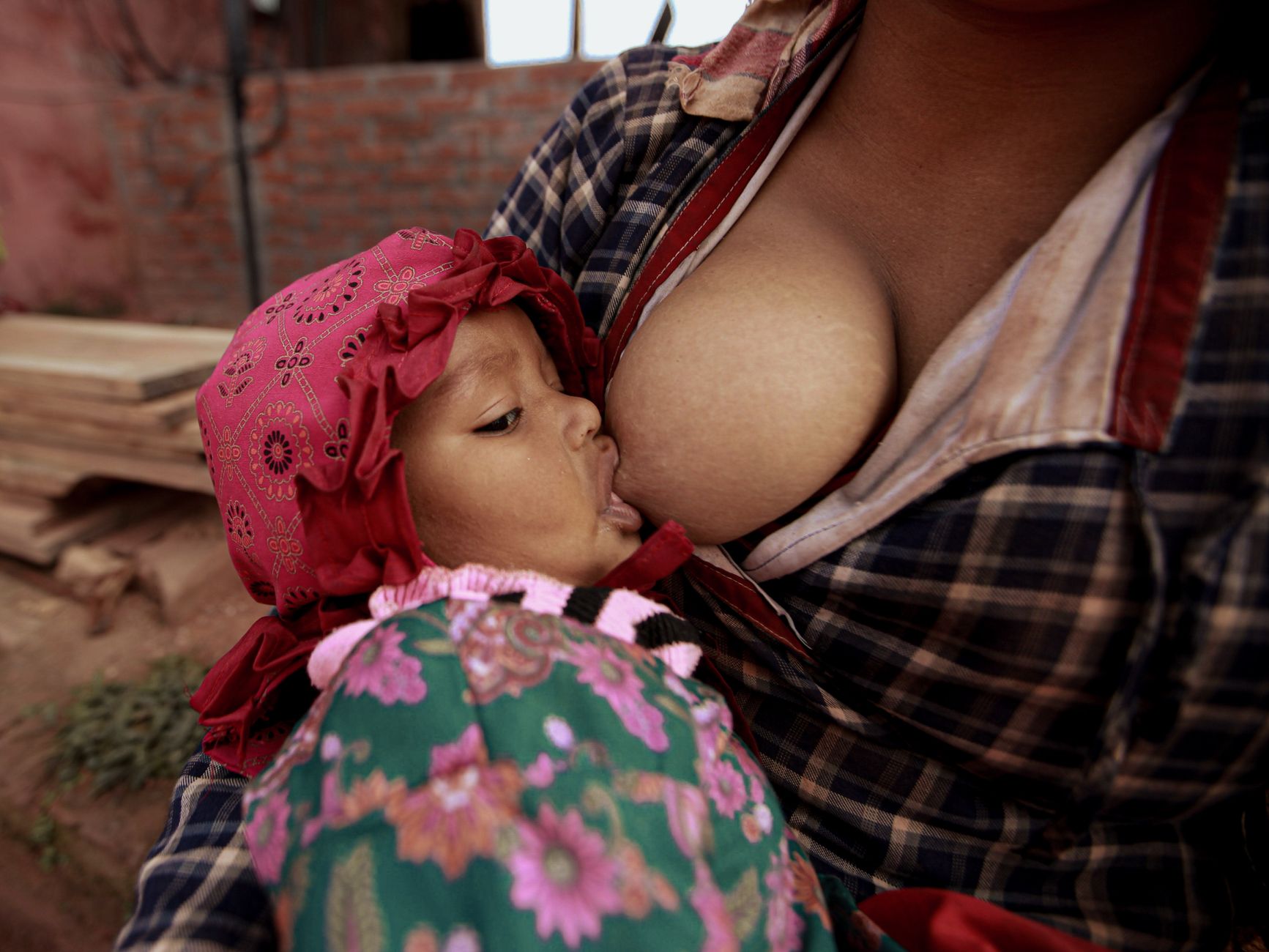 Mother breastfeeding her newborn baby in soft natural light
