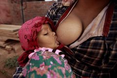 Close-up of a mother breastfeeding her baby outdoors, highlighting the bond and care.