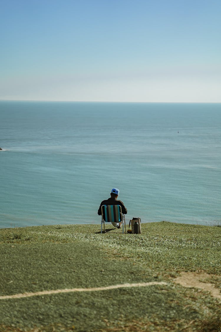 Man Sitting On Sea Shore