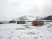 冬日宁静，白雪皑皑的山区点缀着传统蒙古包