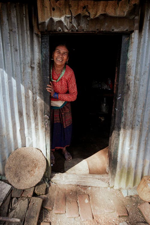 Woman Standing in Doorway of House