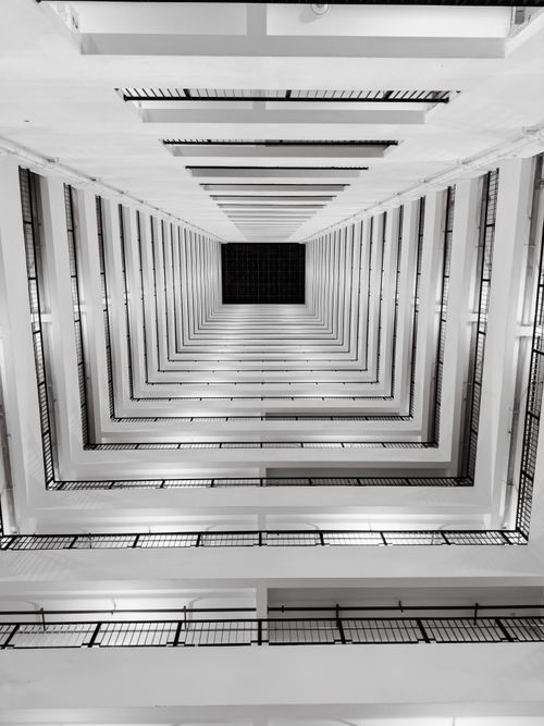Free Dramatic black and white view of a modern vertical staircase from below. Stock Photo