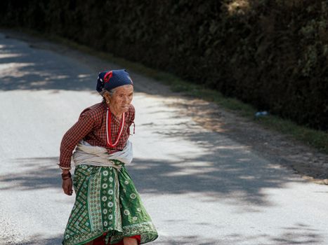 Woman in Red and Green Dress Sitting on Gray Concrete Road
