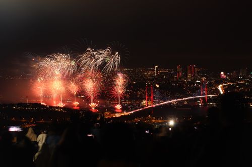 Free A nighttime view of fireworks illuminating the Bosphorus Bridge in Istanbul, Turkey, with a vibrant urban backdrop. Stock Photo