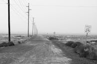 Monochrome Photography of an Empty Road With Speed Limit Sign