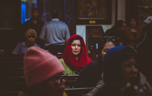 A Woman Wearing Red Headscarf Praying in a Church