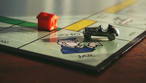 Free Miniature Toy Car on Monopoly Board Game  Stock Photo