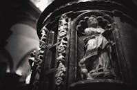 一张西班牙塞维利亚历史悠久的教堂内神圣雕塑的灰度照片