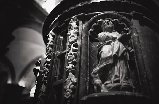 一张西班牙塞维利亚历史悠久的教堂内神圣雕塑的灰度照片