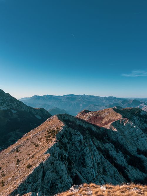 Free Enjoy a scenic view of a stunning mountain range with a pristine blue sky backdrop. Stock Photo