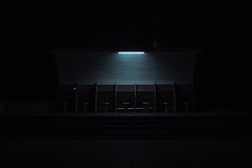 Light over Seats by Wall in Darkness