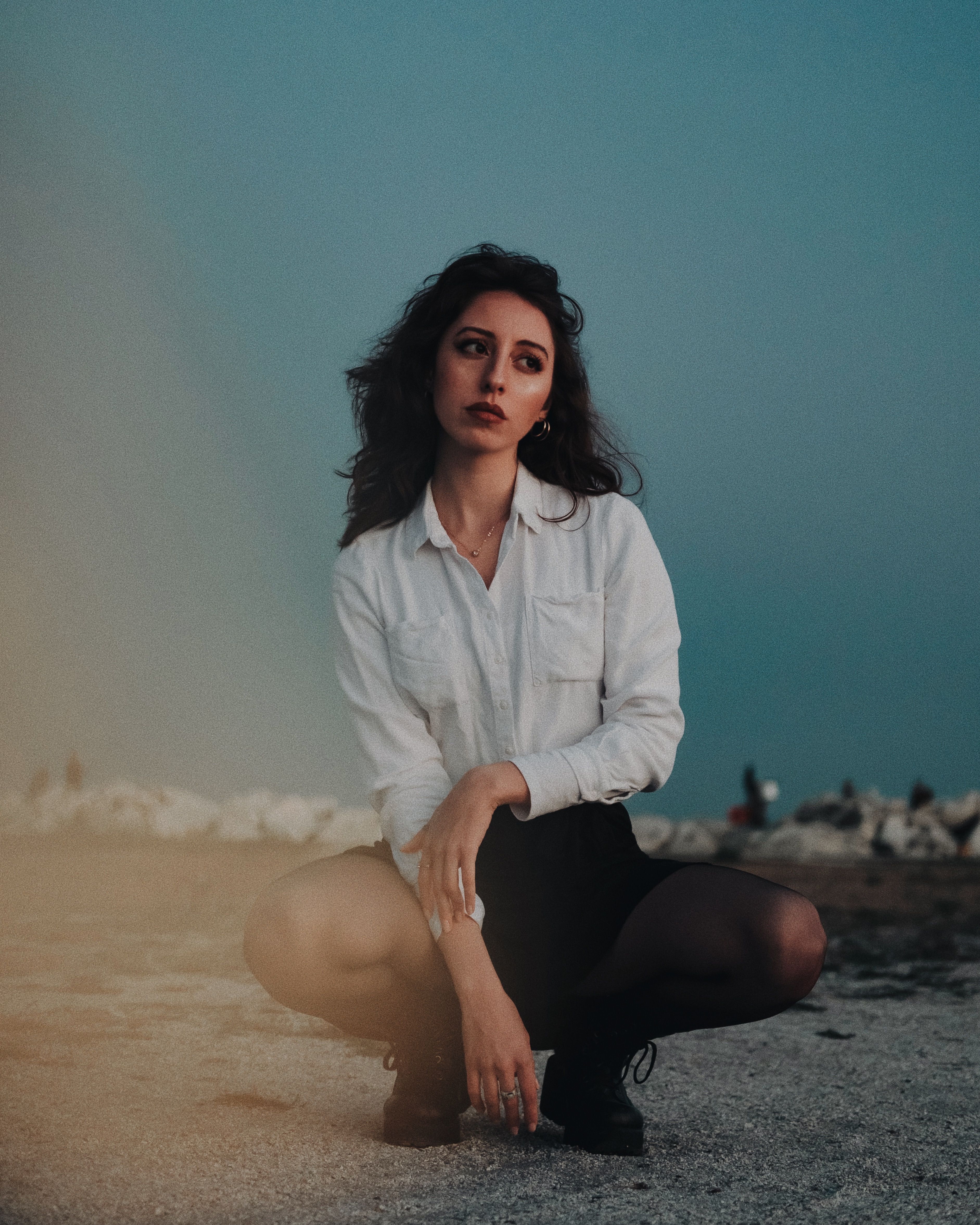Woman Posing in White Long Sleeve Shirt Sitting on a Sand · Free Stock ...