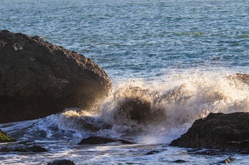 Free Captivating scene of ocean waves crashing against large coastal rocks, depicting nature's power and beauty. Stock Photo