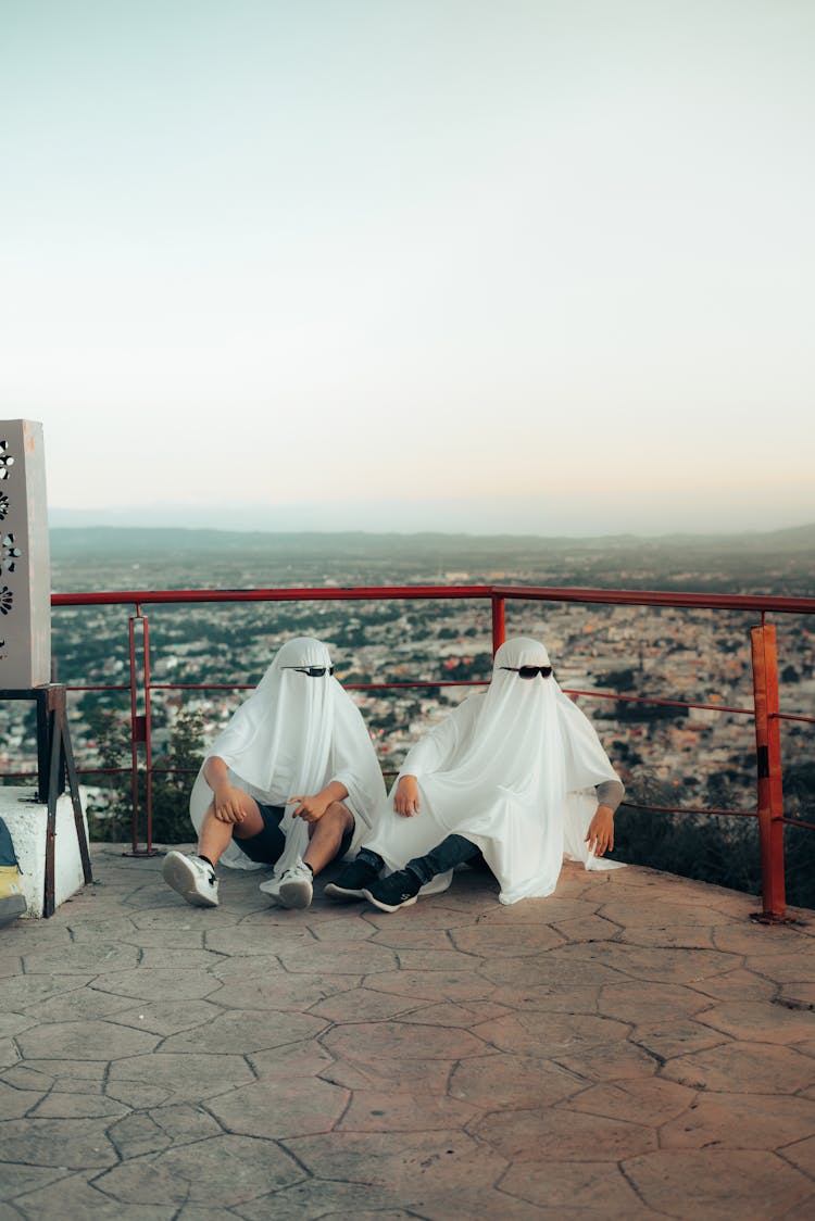 Men Sitting With White Veils On Heads