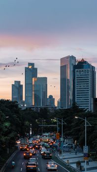 A vibrant cityscape of Guangzhou, China at dusk with skyscrapers and traffic.