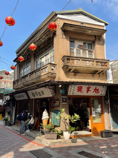 Free Charming vintage building with red lanterns and shops under a clear blue sky. Stock Photo