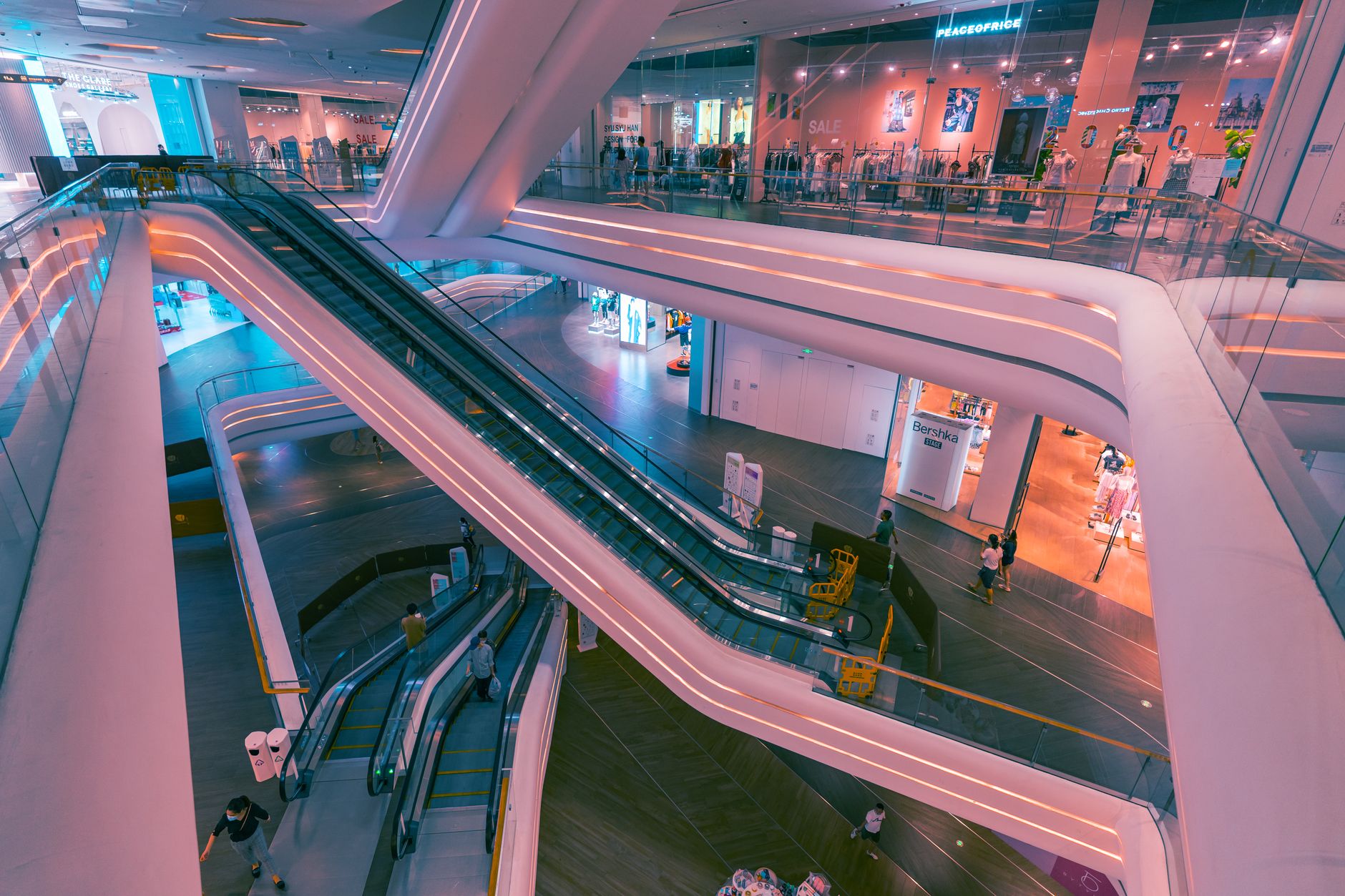 High angle view of a modern shopping mall interior in Shenzhen featuring escalators and shops.