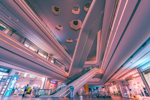 Explore the futuristic design and vibrant lighting of a Shenzhen shopping mall interior.