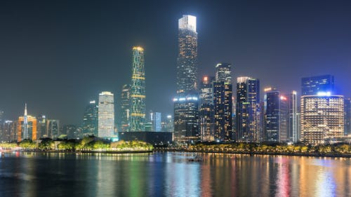 Illuminated Skyscrapers Reflecting in Water at Night 