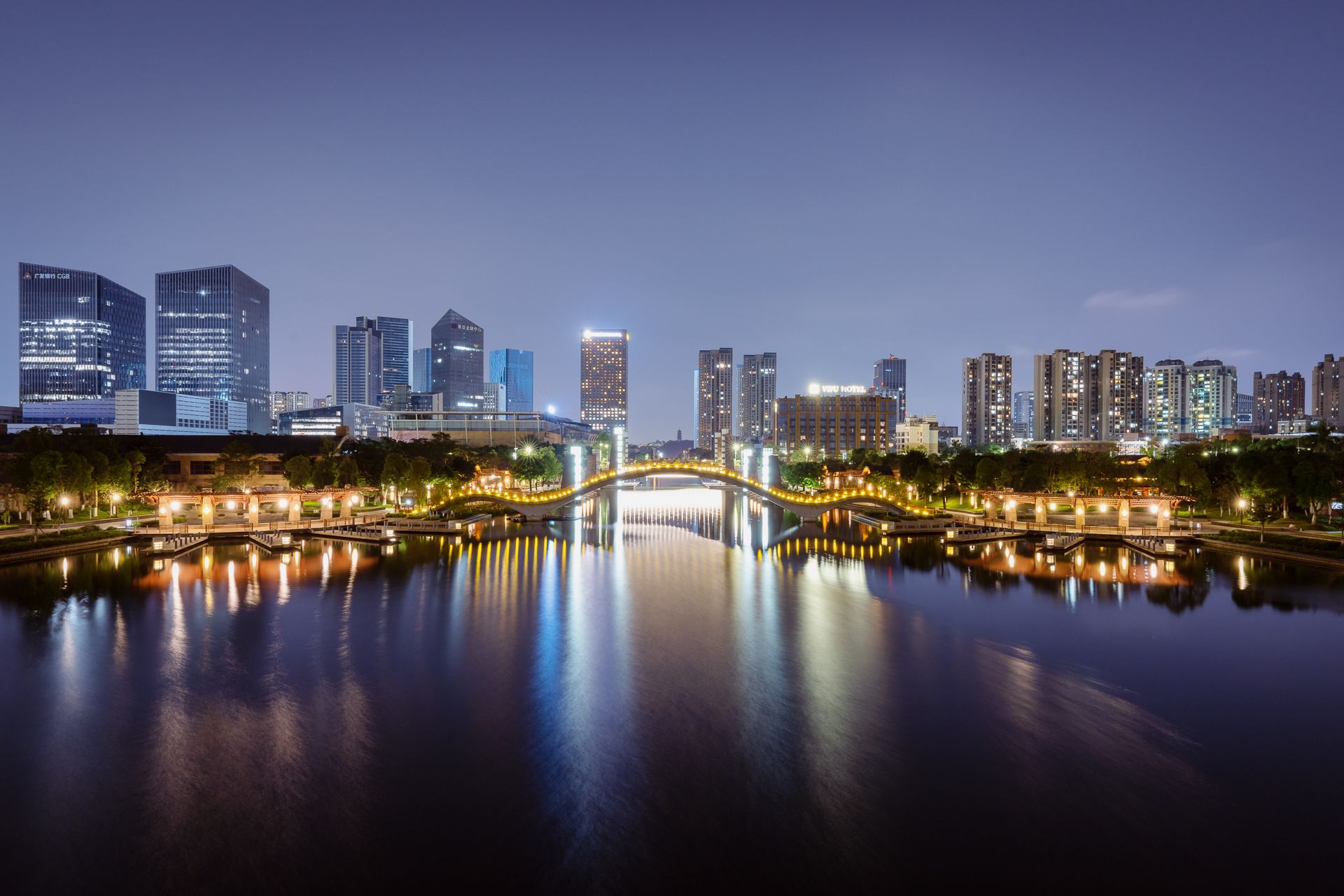 Illuminated skyline and reflections along the river in Foshan, China at night.