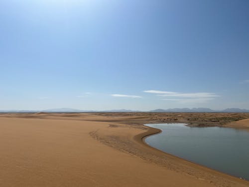 Бесплатное стоковое фото с голубое небо, живописный, коричневый песок