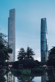 A stunning view of Guangzhou's skyline featuring IFC and CTF Finance Centre amidst lush greenery.