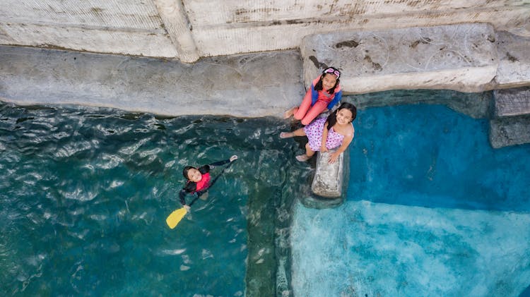 Children Sitting On Poolside