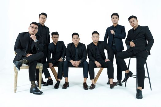 Group of Men in Black Suit Sitting on Brown Wooden Chair