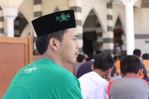 Profile of a man attending a religious gathering in Bandung, an Islamic pesantren setting.
