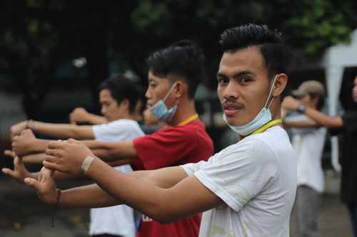 Free Group of young men in West Jakarta, Indonesia, stretching in park setting. Stock Photo