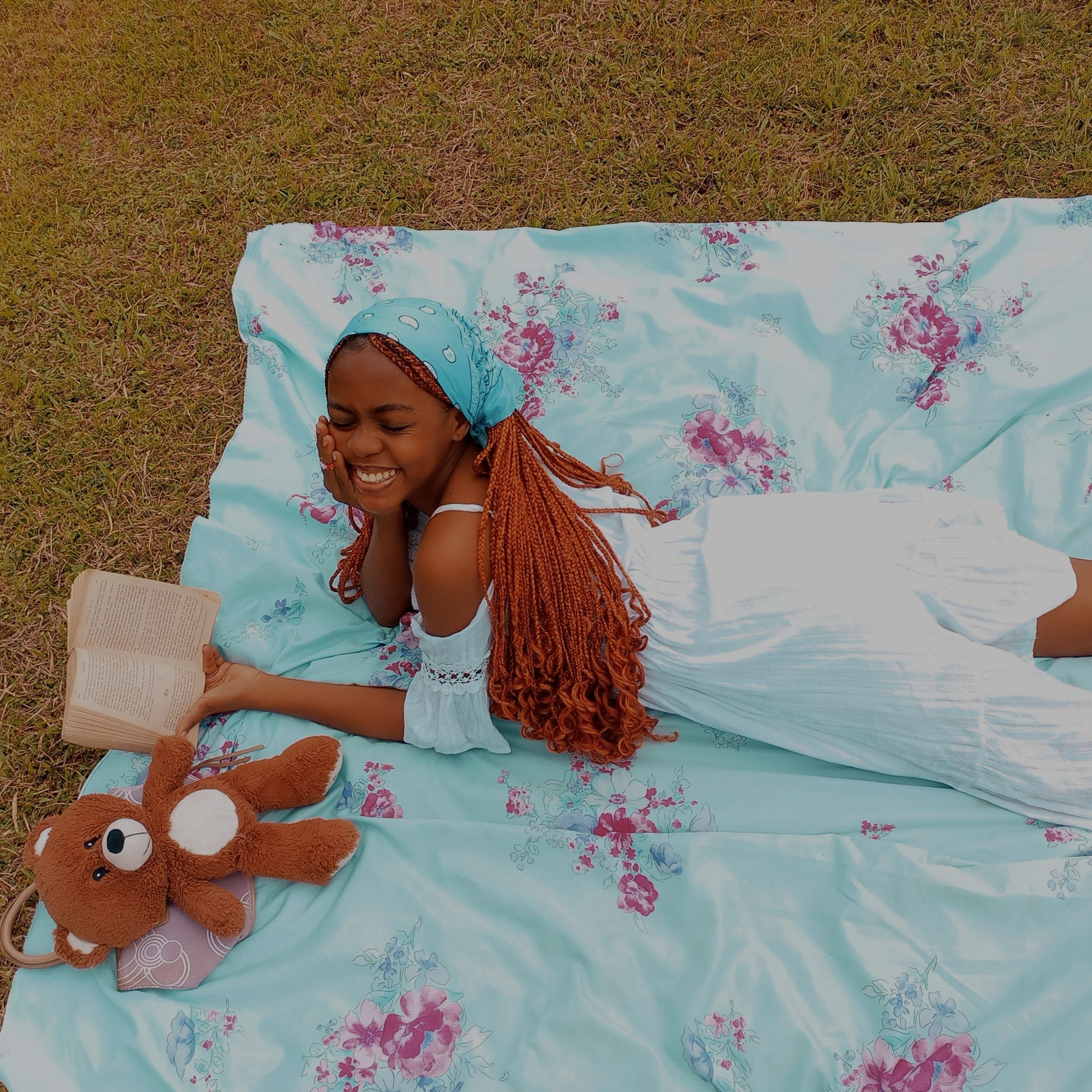 Girl Lying on a Blanket Outside and Reading a Book 