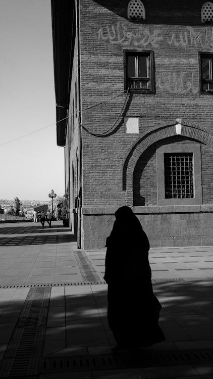 Silhouette of a Person Standing Near a Building