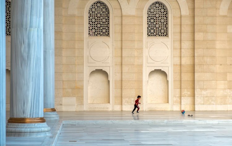 A Kid Running On The Granite Tiled Floor