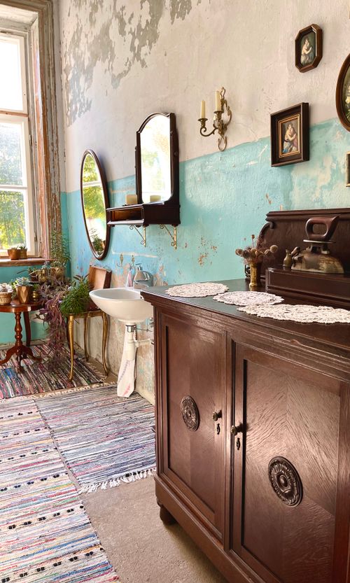 Free Charming vintage bathroom in Lithuania featuring rustic wood furniture, vibrant walls, and antique decor. Stock Photo