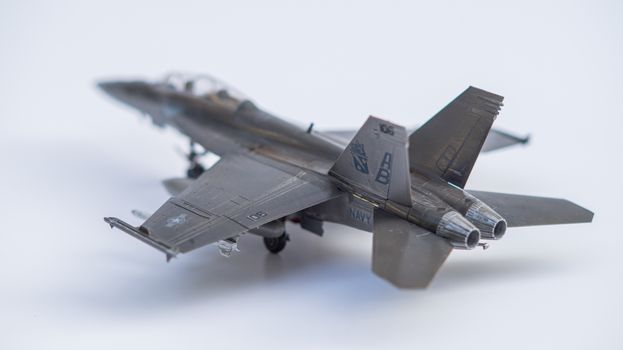 Close-up of a miniature fighter jet model on a white background.