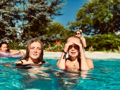 Two Women in Swimming Pool Near Trees