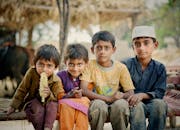 四个年幼的孩子在户外坐着，享受着彼此的陪伴