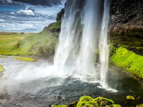 Fotografi Air Terjun Yang Berlalu Waktu Dikelilingi Oleh Tanaman Daun Hijau