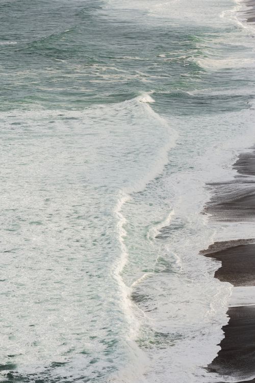 Free Aerial shot of ocean waves crashing on Point Reyes Beach in California. Stock Photo