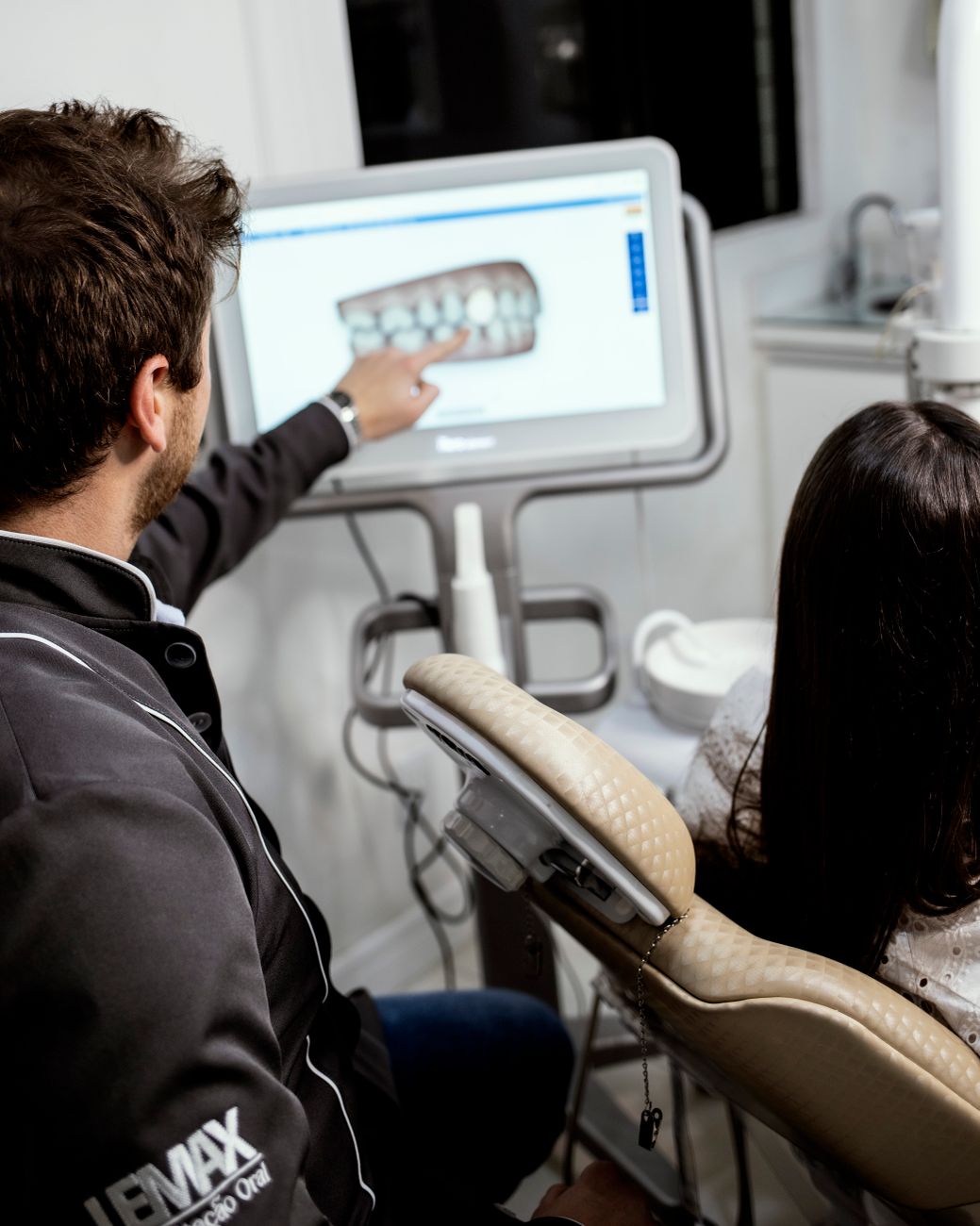 Dentist showing a digital dental model to an adult patient during a consultation.