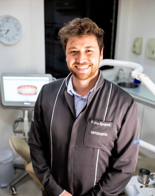 Smiling male dentist in a modern dental clinic, ready to welcome patients.