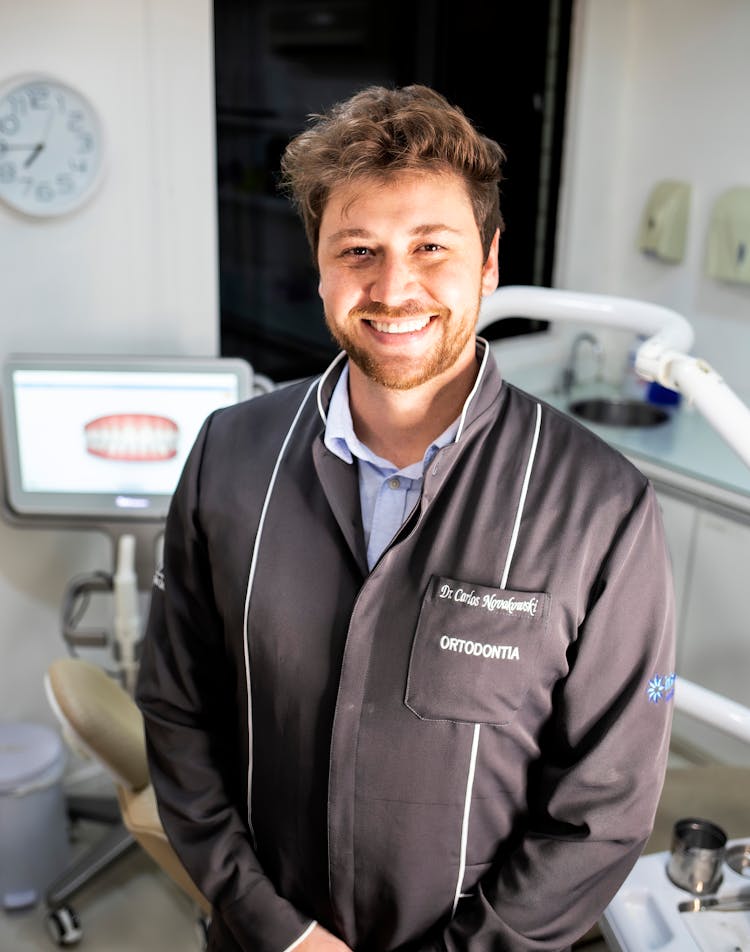 Orthodontist Standing And Smiling In A Clinic 