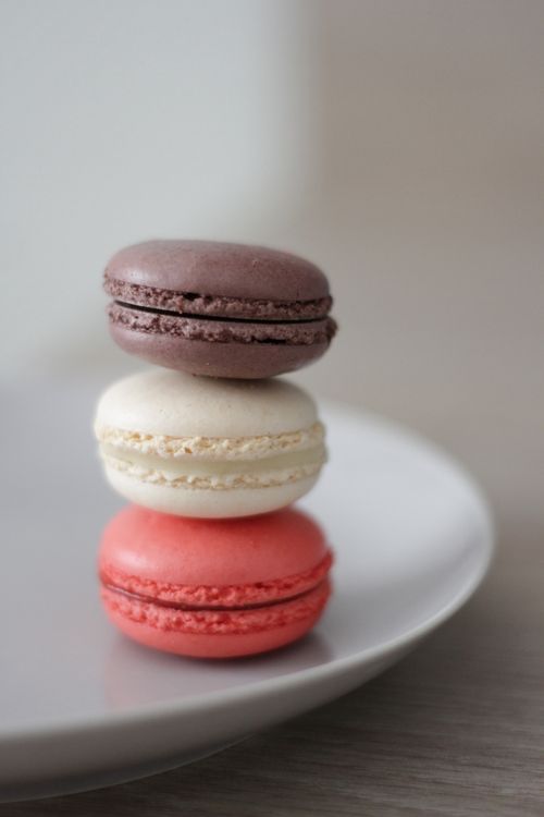 Free Stack of colorful French macarons in vibrant hues on a plate. Stock Photo