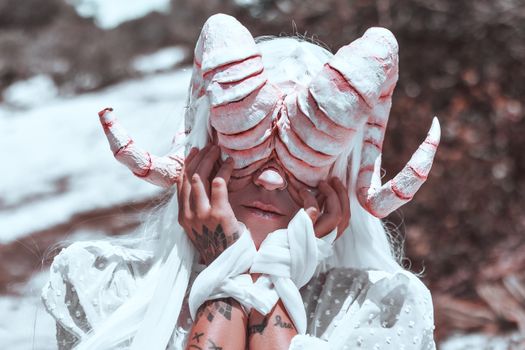 A Person in a White Costume with Horns for Eyes