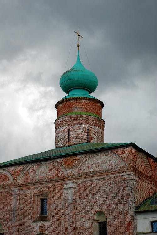 Brick Church with Tower against Cloudy Sky
