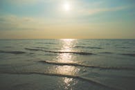 在英国福姆比海滩平静的水面上，日落宁静地映照出一片祥和的海景