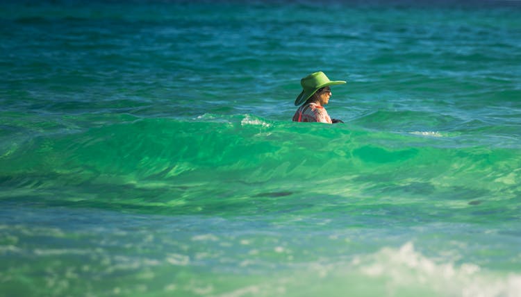 Woman In Green Hat Swimming In Sea