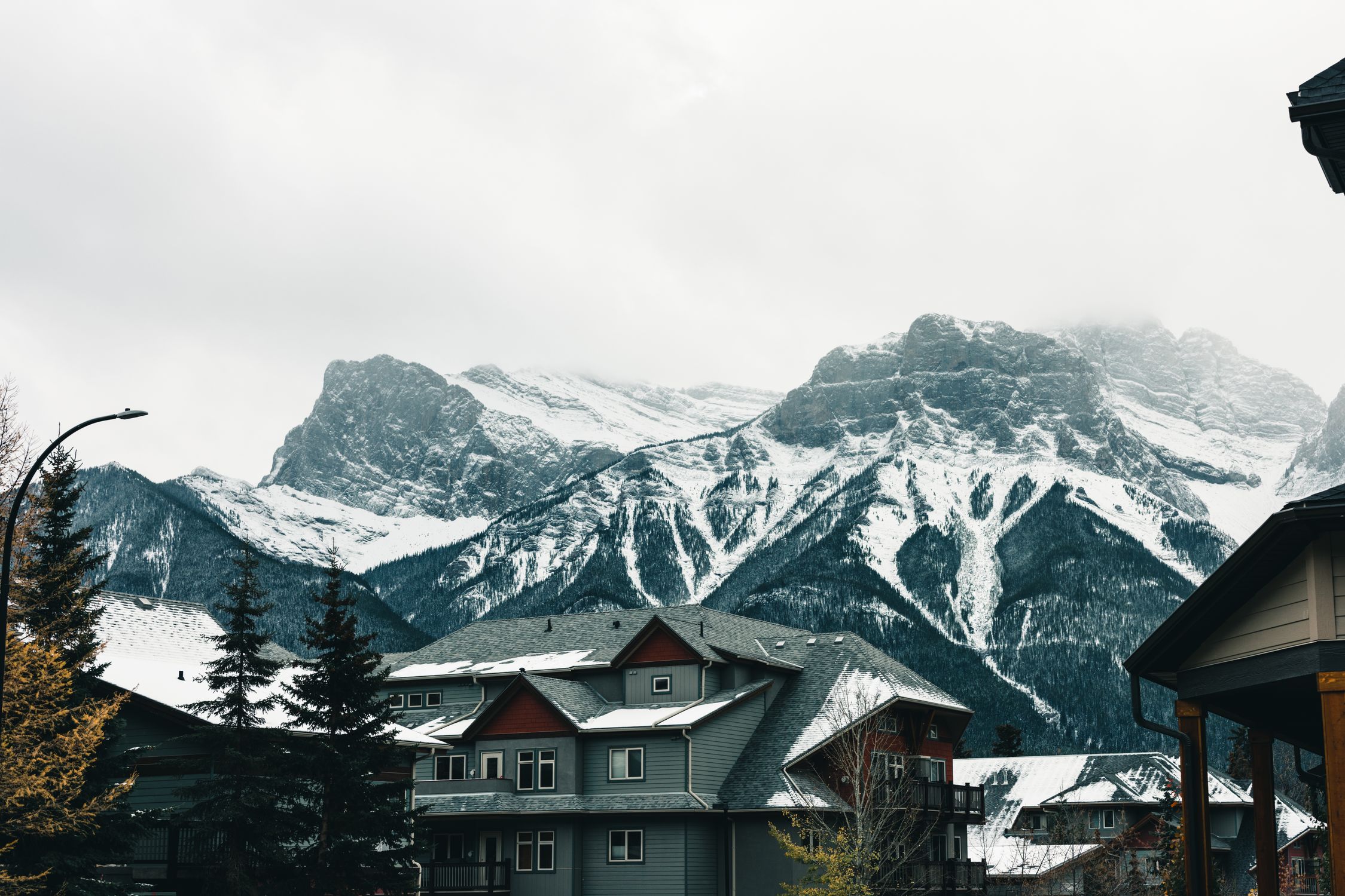 Picturesque winter view of Canmore's snow-covered mountains and cozy houses.