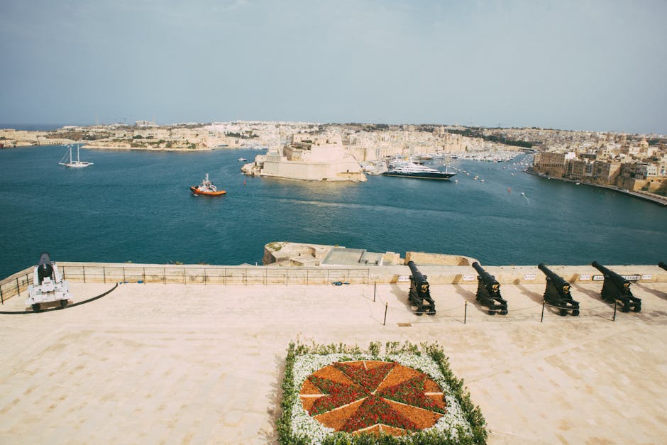 Aerial view of the Saluting Battery and Grand Harbour in Valletta, Malta, showcasing cannons and waterfront.